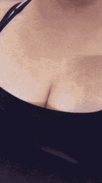 a close up of a woman 's breast in a black top