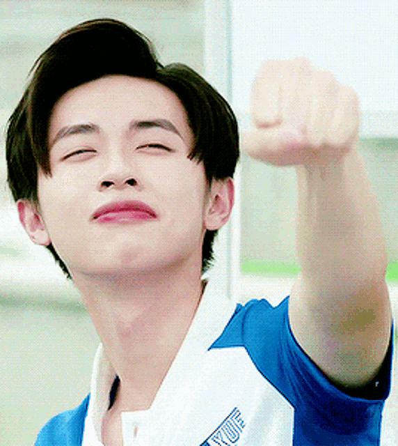 a young man wearing a blue and white shirt with yufu written on it