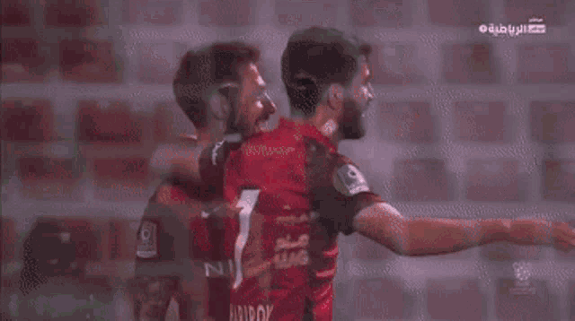 two soccer players are hugging and one has the number 1 on his shirt