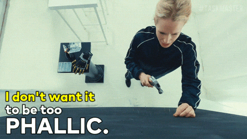 a woman holding a gun with the words " i don t want it to be too phallic " below her