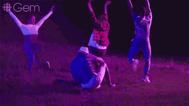 a group of people are dancing in a field with a gem logo