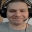 a man is wearing headphones and a microphone and smiling .