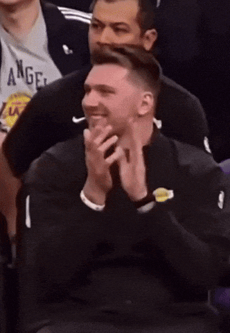 a man wearing a lakers jacket is clapping