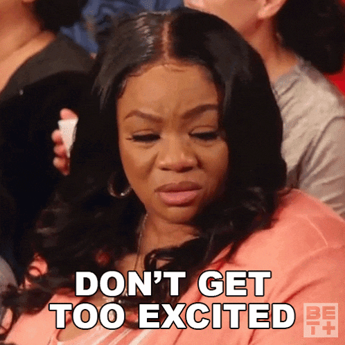 a woman is sitting in a crowd and says do n't get too excited .