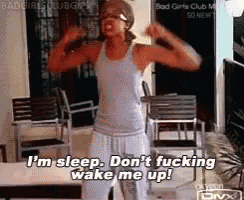 a woman is flexing her muscles while saying i 'm sleep don 't fucking wake me up