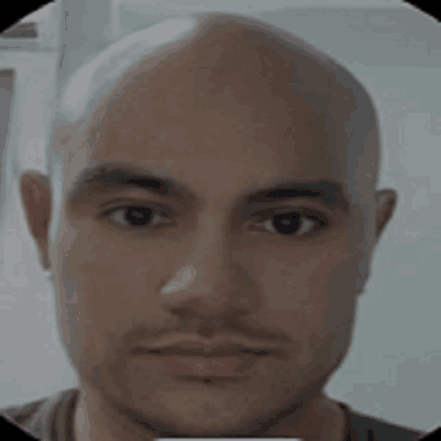 a close up of a bald man 's face