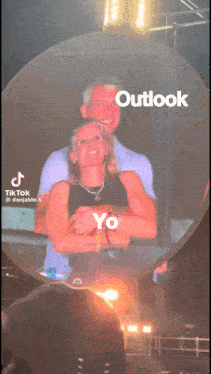 a tiktok video of a man and woman hugging with outlook written on the bottom