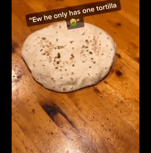 a tortilla on a wooden table with a caption that says ew he only has one tortilla