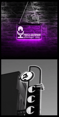 a purple sign that says french leadership conference hangs from a brick wall