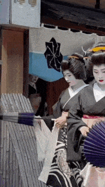 a woman in a black kimono is holding a fan in front of a blue and white flag with a cross on it