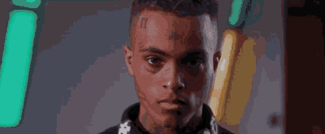 a close up of a man with a tattoo on his face