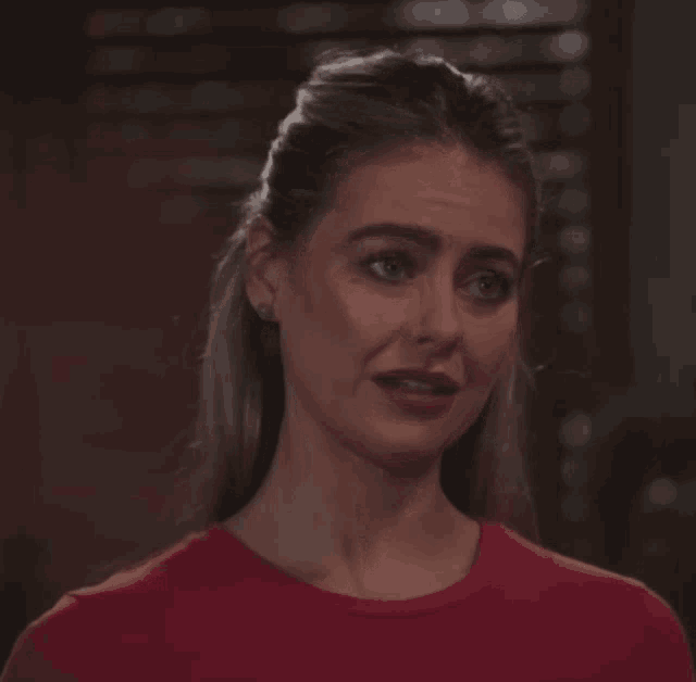 a woman in a red shirt is crying