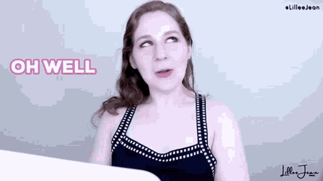 a woman in a black and white tank top is saying oh well .