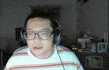 a man wearing glasses and headphones in front of a tv