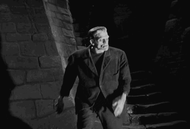 a man in a black suit is walking down stairs