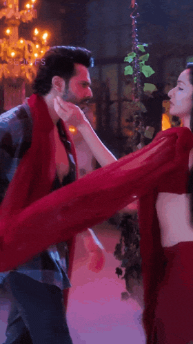 a man and woman are dancing together and the woman is wearing a red dress