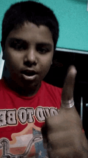 a young boy wearing a red shirt that says ' motorcycle ' on it