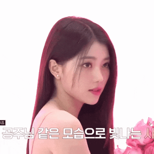 a woman with long red hair is standing in front of a white background with korean writing on it