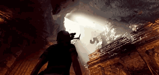a person standing in a cave with a shadow of a person on the wall