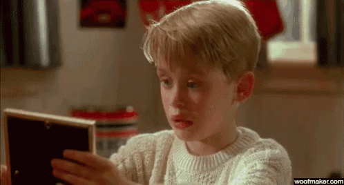 a young boy is looking at a picture frame and crying