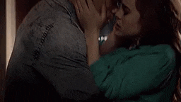 a man and a woman are kissing in a dark room .