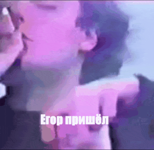 a close up of a person 's face with a purple background and a foreign language written on it
