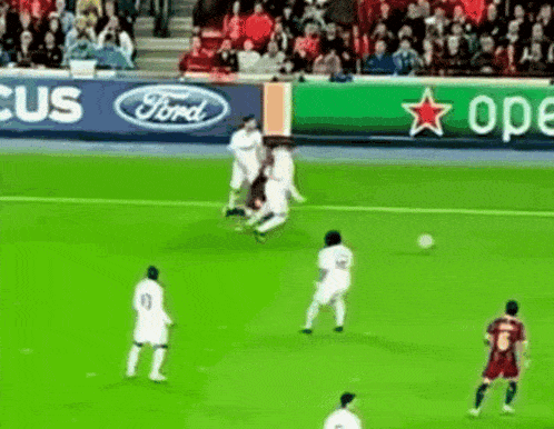 a group of soccer players on a field with a ford and heineken banner behind them