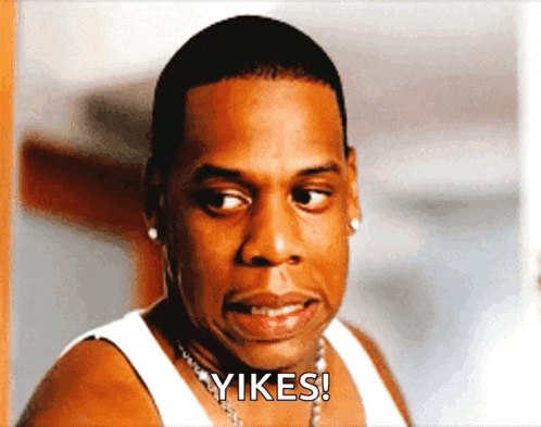 a man wearing a white tank top says " yikes " in front of his face
