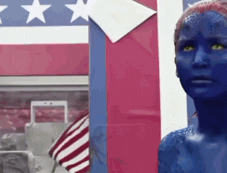 a woman with blue paint on her face stands in front of an american flag .