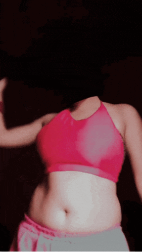 a woman without a head is wearing a pink crop top and grey shorts