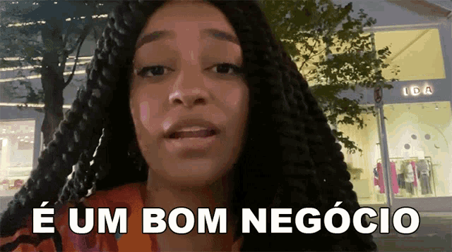 a woman says " e um bom negocio " in front of a store