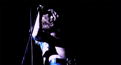 a woman is singing into a microphone on a stage .