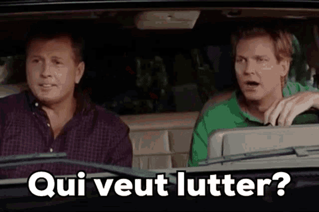 two men are sitting in a car and one of them is asking the other , `` qui veut lutter ? ''