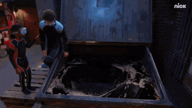 a man in a scuba suit stands in front of a dumpster that says nick on the bottom