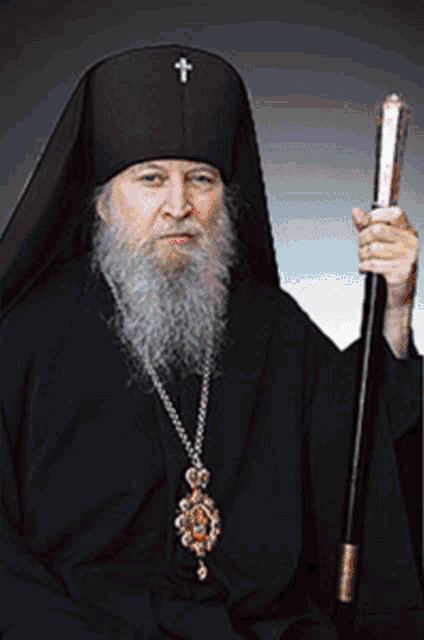 a man with a beard and a cross on his hat