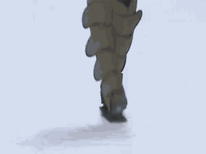 a woman wearing a gray coat and green boots is walking down a runway at a fashion show .