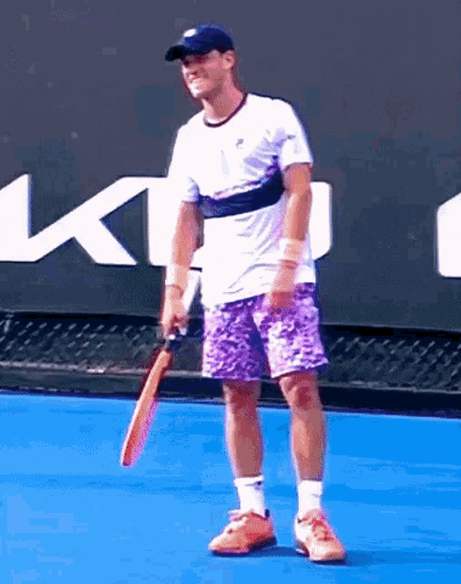 a man holding a tennis racquet on a tennis court