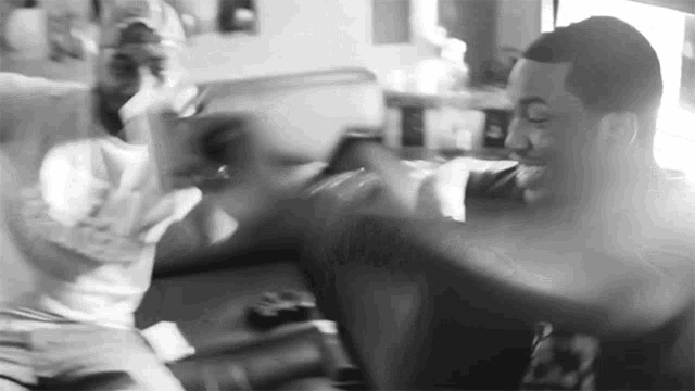 two men are sitting on a couch playing with each other
