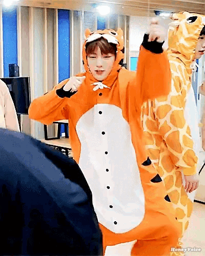 a man in a tiger costume stands next to another man in a giraffe outfit