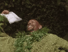 a man is laying on top of a pile of grass .