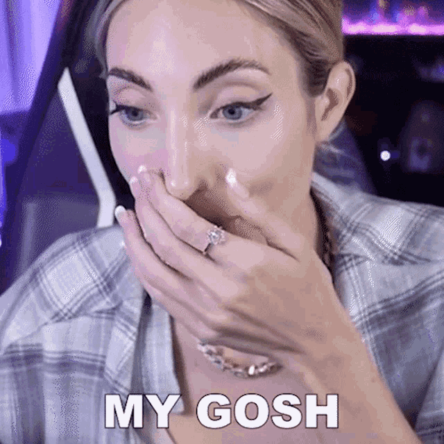 a woman with a ring on her finger is covering her mouth with her hand and the words my gosh are visible