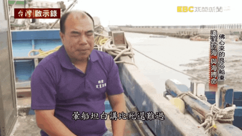 a man in a purple shirt has chinese writing on his shirt
