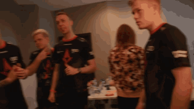 a blurry picture of a group of people with one wearing a black shirt that says ' astralis ' on it