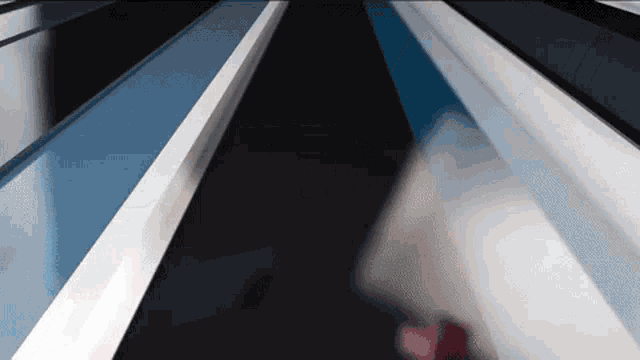 a blurred image of a person walking down a staircase