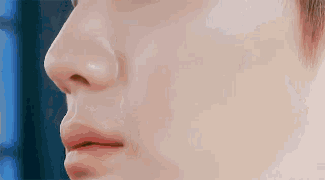 a close up of a person 's face with a tear running down his nose