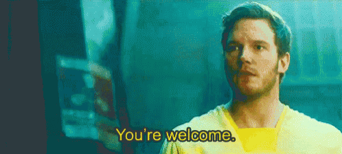 a man in a yellow shirt is standing in front of a screen and says `` you 're welcome '' .