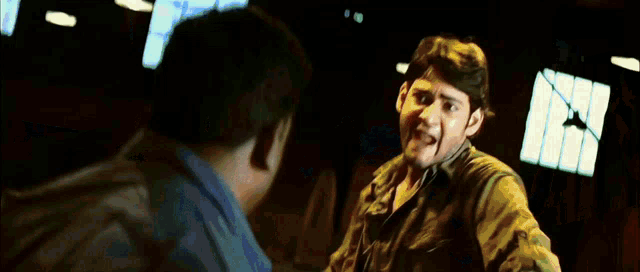 a man in a brown jacket is fighting another man