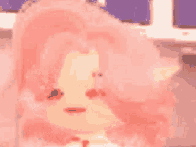 a close up of pink cotton candy with a candle in the background