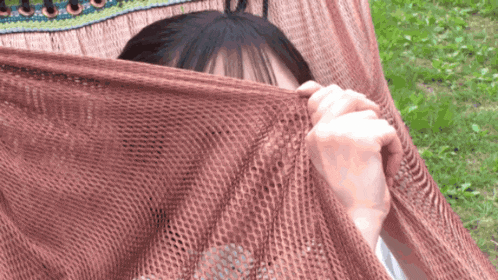 a person covering their face with a blanket