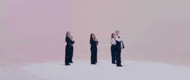 a group of women in suits are dancing together